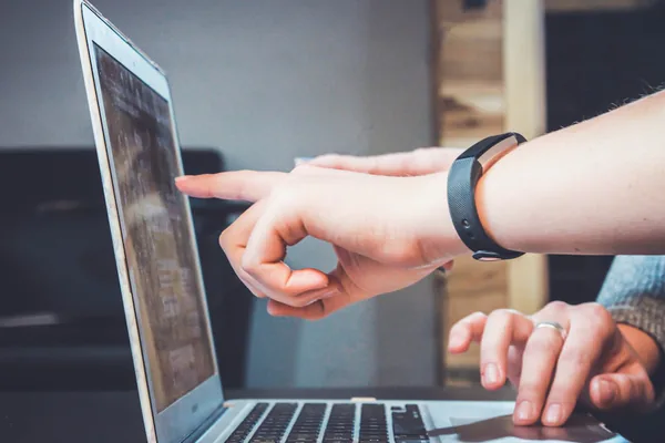 Eine Hand zeigt auf den Bildschirm eines Laptops, eine zweite liegt auf dem Trackpad – Sinnbild für Computer Use mit GPT-6.1 Terra