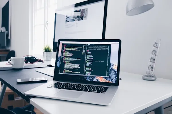 Laptop mit Programmcode – individuelle Software- und App-Entwicklung bei Lyron