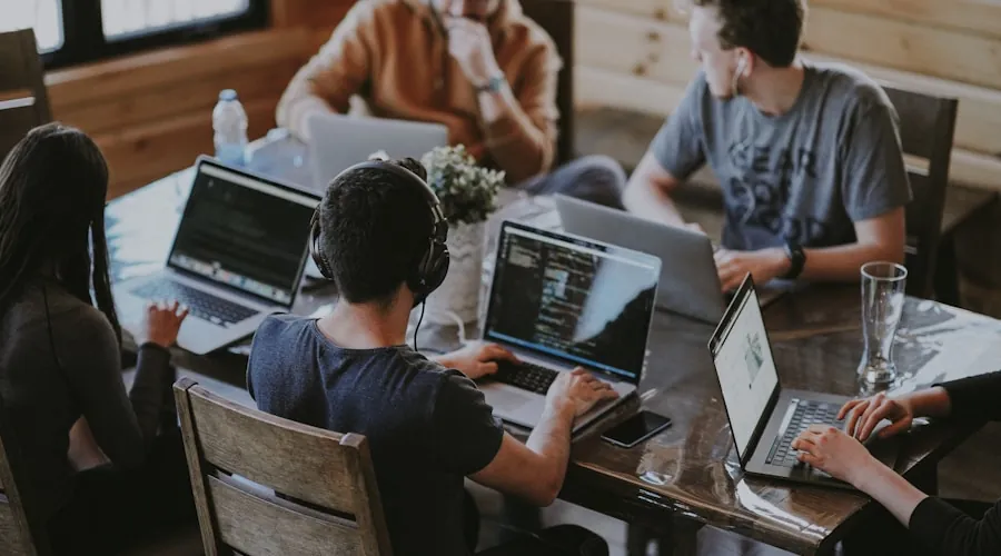 Team arbeitet konzentriert am Tisch zusammen – Zeit für echte Arbeit statt Routineaufgaben