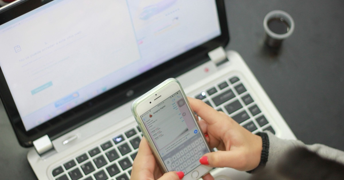 Hand hält ein Smartphone mit geöffnetem Chat-Verlauf – WhatsApp Business 2026 für den Mittelstand