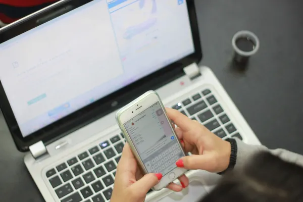 Hand hält ein Smartphone mit geöffnetem Chat-Verlauf – WhatsApp Business Messaging für den Mittelstand